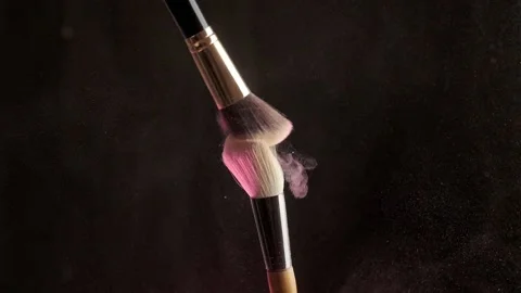 From the touch of two makeup brushes, colorful glittering powder or blush Stock Footage 194395414