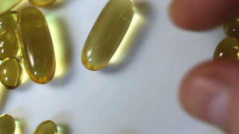 Touch with your hands a large oval shiny transparent yellow capsule. Real-time, Stock Footage 145108194