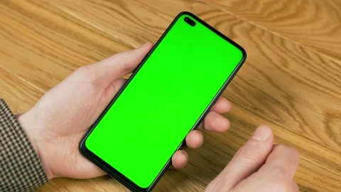Touches a Green Screen Background Cell Phone on the Wood Surface, Chroma Key, Al Video stock 145749957