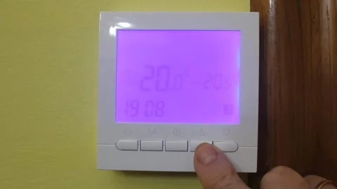 Touching the buttons of a heating thermostat Stock Footage 322026886