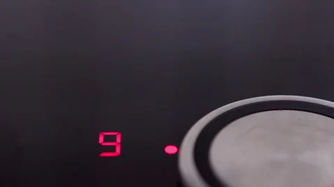 Touching the control panel of an induction cooktop, adjusting the temperature to Stock Footage 281597476