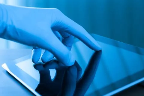 Touching digital tablet in glove Stock Photos