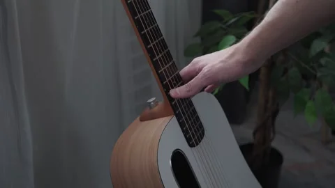 Touching guitar strings in close-up Stock Footage 329971340
