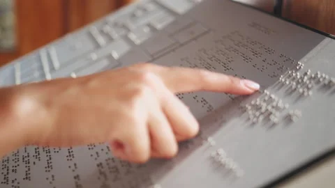 Touching letters on sheet of paper close-up, blindman reading braille book using Stockbeeldmateriaal 167090764