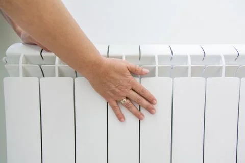 Touching the radiator to check whether heated Stock Photos