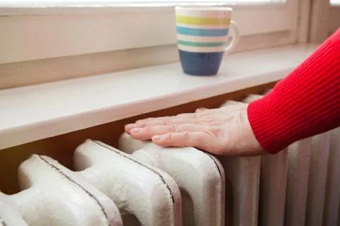 Touching the radiator to check whether heated Stock Photos