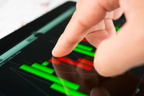 Touching screen of tablet pc with market graph Foto stock