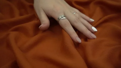 Touching sensitive rust colored fabric in slow motion. Woman's hand softly strok Stock Footage 120128856