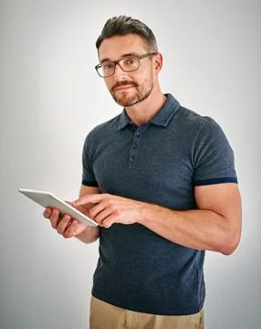 Touchscreen technology is the way to go. a man using a digital tablet against a Stock Photos