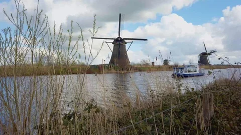 Tour boat in front of a windmill at Kinderdijk 動画素材 104779497