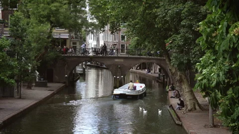 Tour boat sailing under an arched bridge on Utrecht's Oudegracht canal 库存影片 340230714