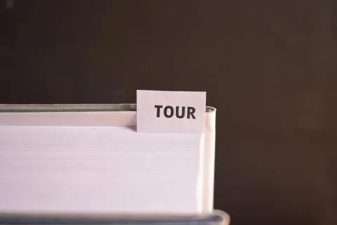 Tour Bookmark Inserted in Book Representing Travel, Adventure and Tourism Fotos Stock