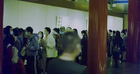 Tour group exhibit museum while walking around red pillars Stock Footage 143396730