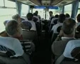 Tour group on travelling coach listening to tour guide SD Footage