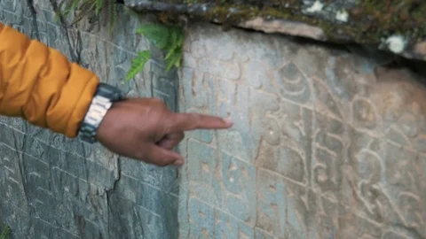 Tour Guide Teaching about Buddhist Mantra Carved on Stone Wall - 4K Footage Stock Footage 104558027