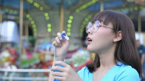 Tourism concept. A girl blowing bubbles in an amusement park. 4k Resolution. Stock Footage