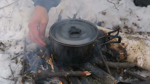 Tourism, a man puts the bars in the fire, cooks soup in the campaign, Video stock 89884746