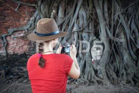 Tourist and Head of Buddha in Thailand Stock Photos