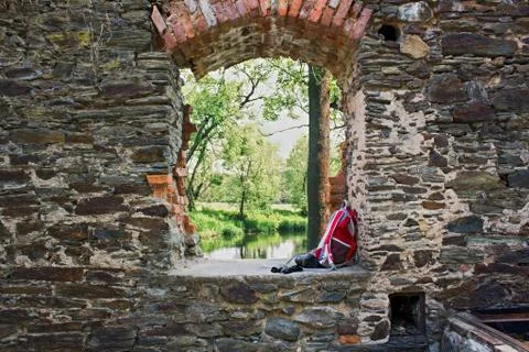 Tourist backpack and camera in window of old ruins. Stock Photos