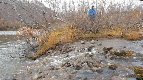 Tourist with a backpack goes through a mountain stream. View from the bottom. Video stock 97298637