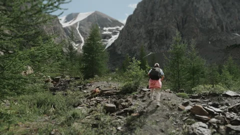 A tourist with a backpack on his back walks along a mountain path. Stock Footage 281160247