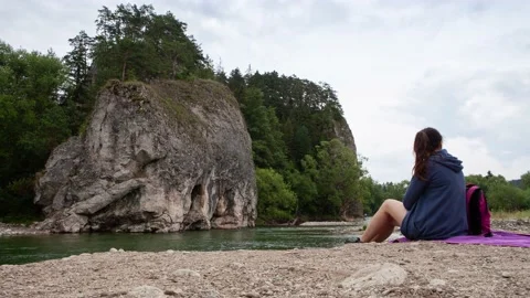 Tourist with a backpack sitting by the river. Stock Footage 152239038