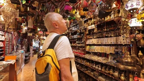 Tourist with a backpack in a small oriental store, chooses souvenirs . Stock Footage 117252212