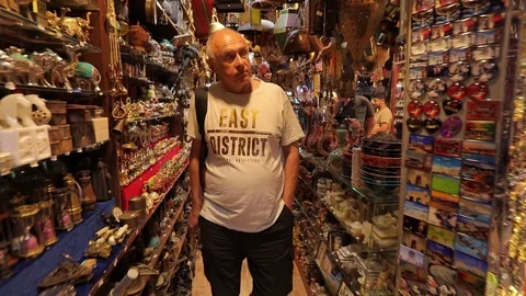 Tourist with a backpack in a small oriental store, chooses souvenirs . Stock Footage 117252225
