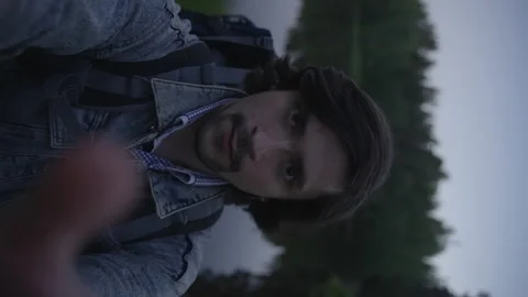 A tourist with a backpack takes a selfie on the camera, vertical view. Stock-Footage 201129706