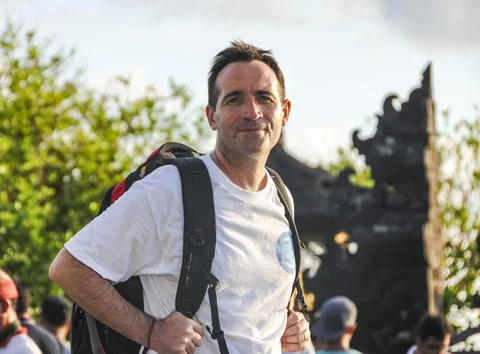 A tourist with a backpack visiting Bali while looking at camera. Stock Photos