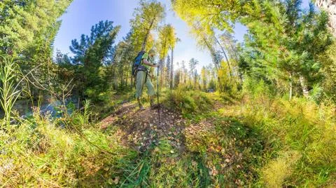 Tourist with a backpack walking through the forest with rocks Stock Photos