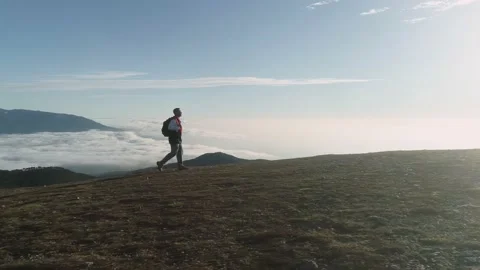Tourist with backpack walks above clouds Stock Footage 168522854