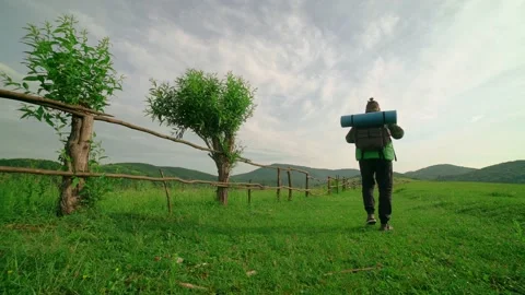 A tourist with a backpack walks along the path,in the background of the mountain Stock Footage 198318787