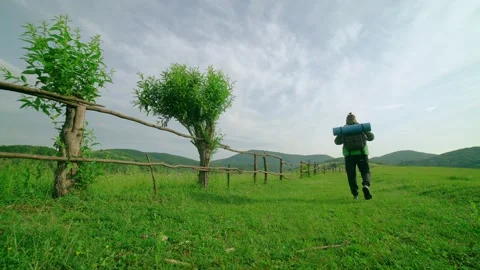 A tourist with a backpack walks along the path,in the background of the mountain Stock Footage 198503594