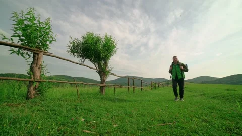 A tourist with a backpack walks along the path,in the background of the mountain Vidéo 199101070