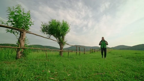 A tourist with a backpack walks along the path,in the background of the mountain Stock Footage 201039530