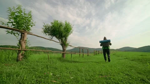 A tourist with a backpack walks along the path,in the background of the mountain Stock Footage 201039532