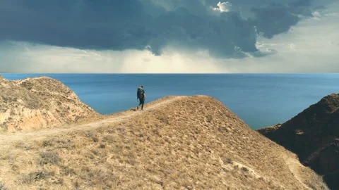 The tourist with backpack walks on the mountain range on the beautiful seascape Video stock 143039313
