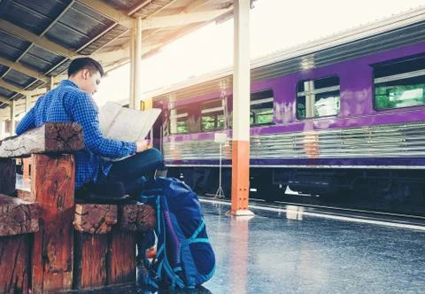 Tourist backpacker using map to travel at train station Stock Photos