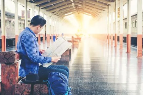 Tourist backpacker using map to travel at train station Stock Photos