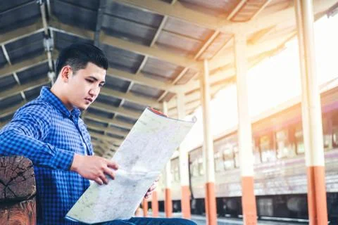 Tourist backpacker using map to travel at train station Stock Photos