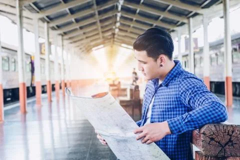 Tourist backpacker using map to travel at train station Stock Photos
