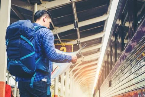 Tourist backpacker using map to travel at train station Stock Photos