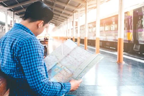 Tourist backpacker using map to travel at train station Stock Photos