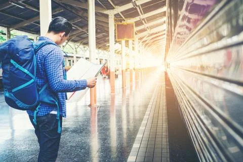 Tourist backpacker using map to travel at train station Stock Photos
