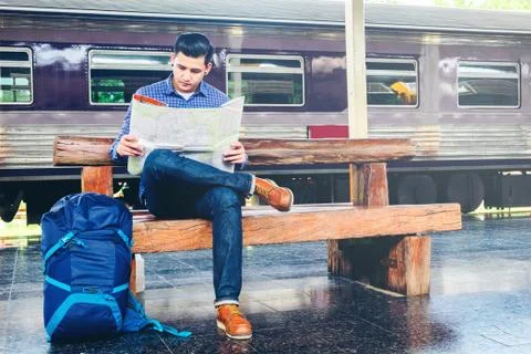 Tourist backpacker using map to travel at train station Foto stock