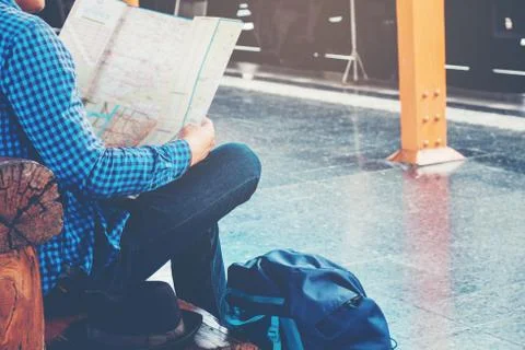 Tourist backpacker using map to travel at train station Foto stock