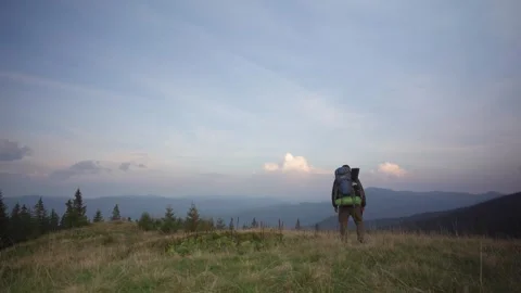 Tourist with a big backpack standing on the top, Mountains, beautiful sunset Stock Footage 250598035