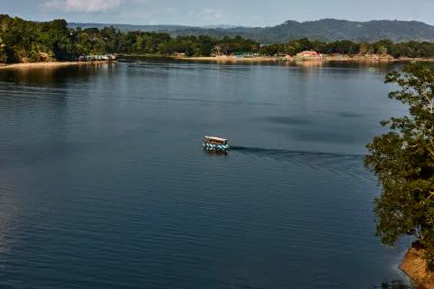 Tourist boat cruises over the calm waters of the Kaptai Lake in a sunny after Stock Photos