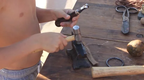 Tourist Boy is Using Hammer, Anvil, Rope During His Work with the Leather Stock Footage 58443041